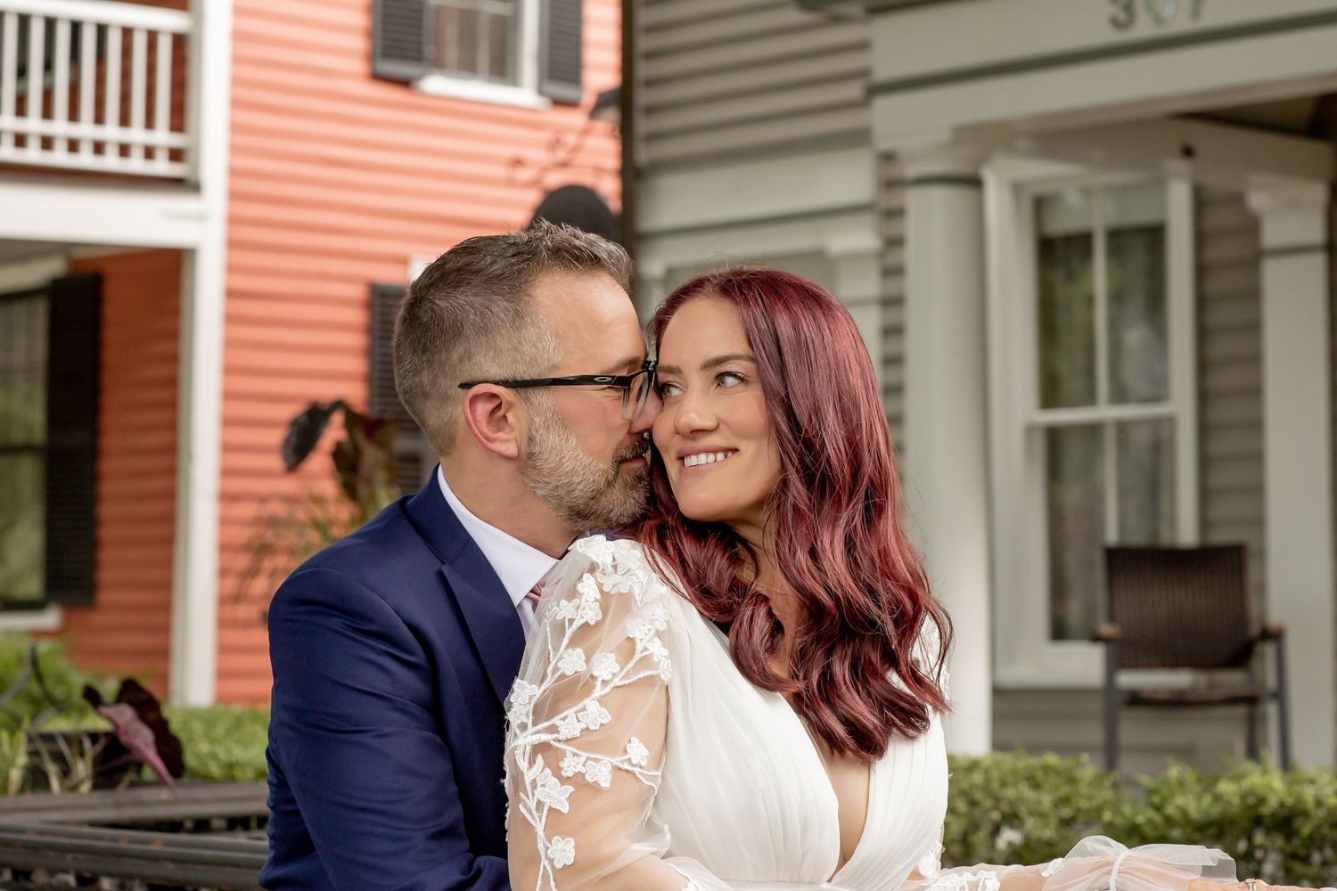 Wedding couple sharing a romantic kiss outside a charming historic building.