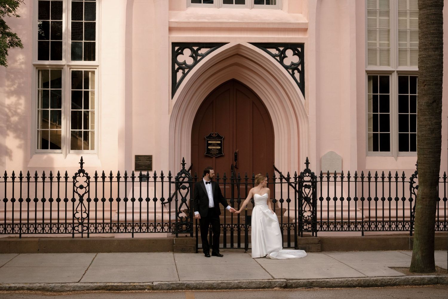 The exterior of a pink Gothic Revival church with ornate architectural details.