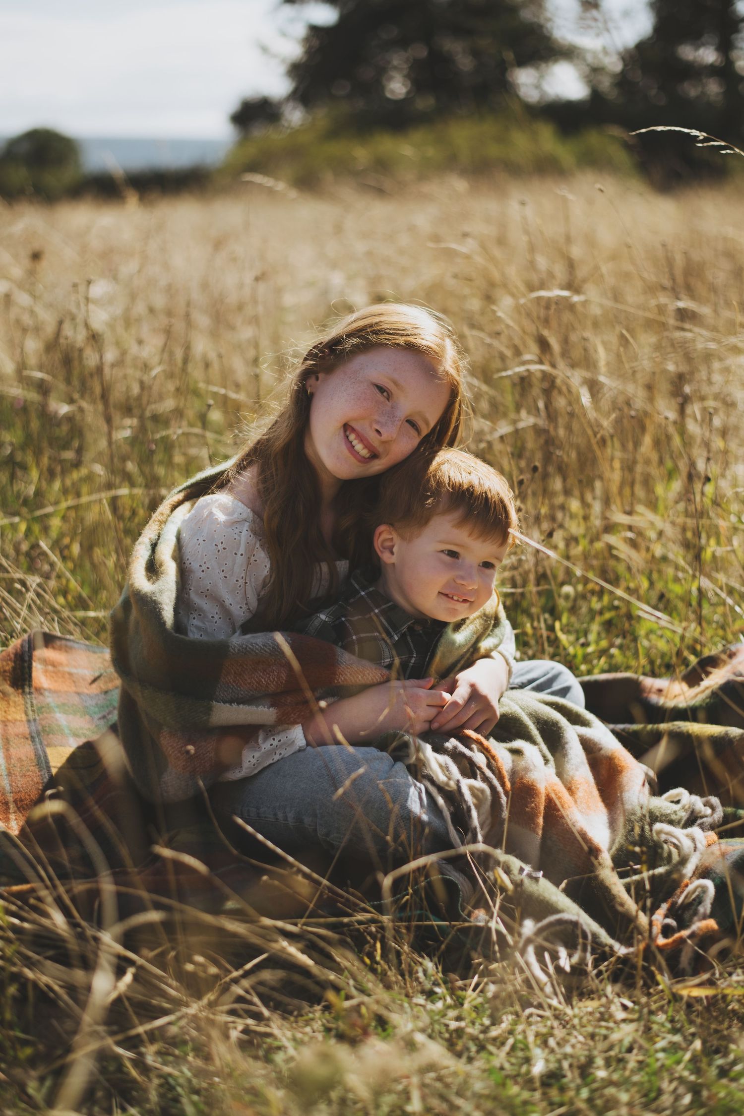 Relaxing together in tall grass on a sunny autumn day.