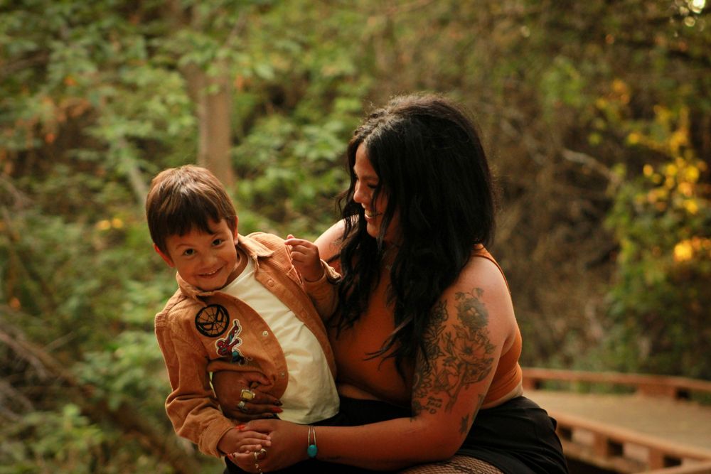 Candid moment between adult and child sharing laughter on wooden walkway.