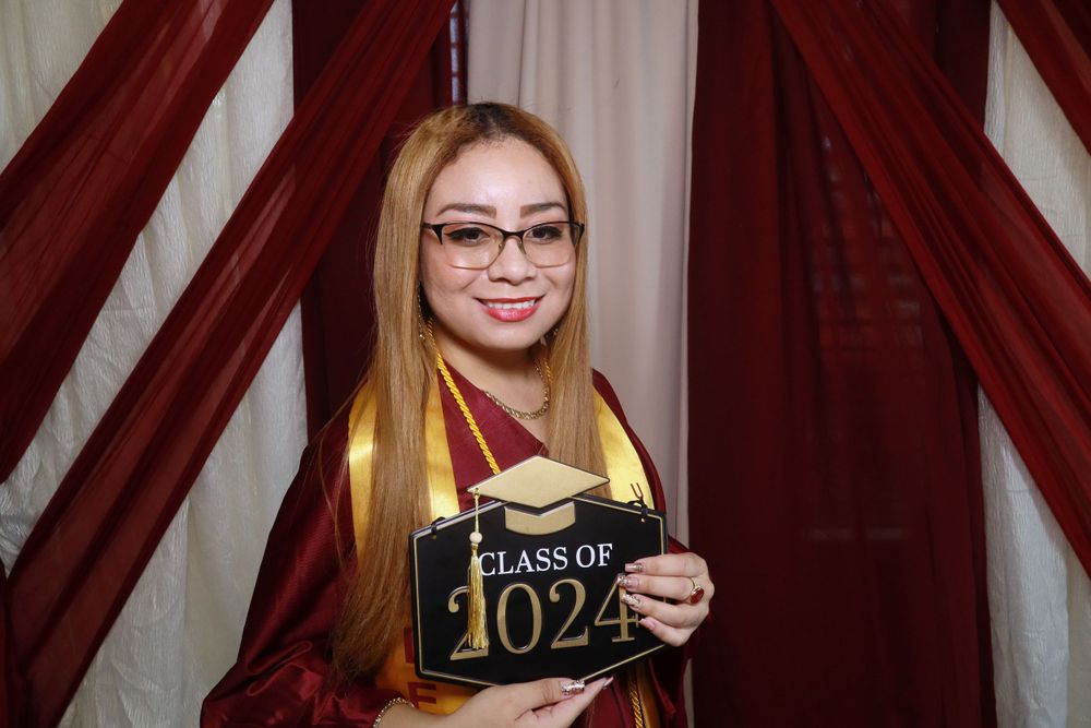 Proud graduate smiling and striking a pose at the selfie booth!