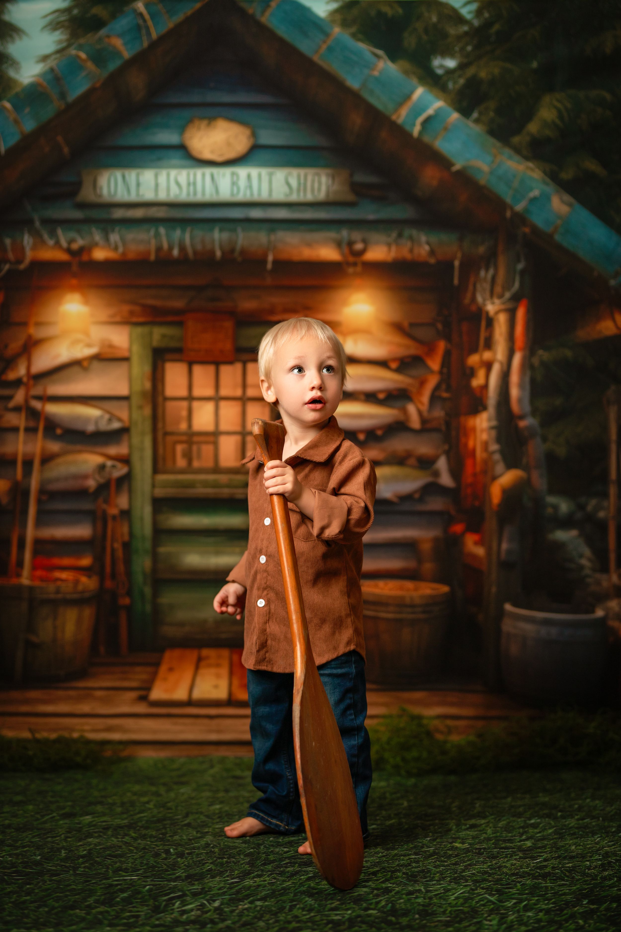 A child in a brown jacket stands barefoot in front of a rustic bait shop with glowing warm lights.