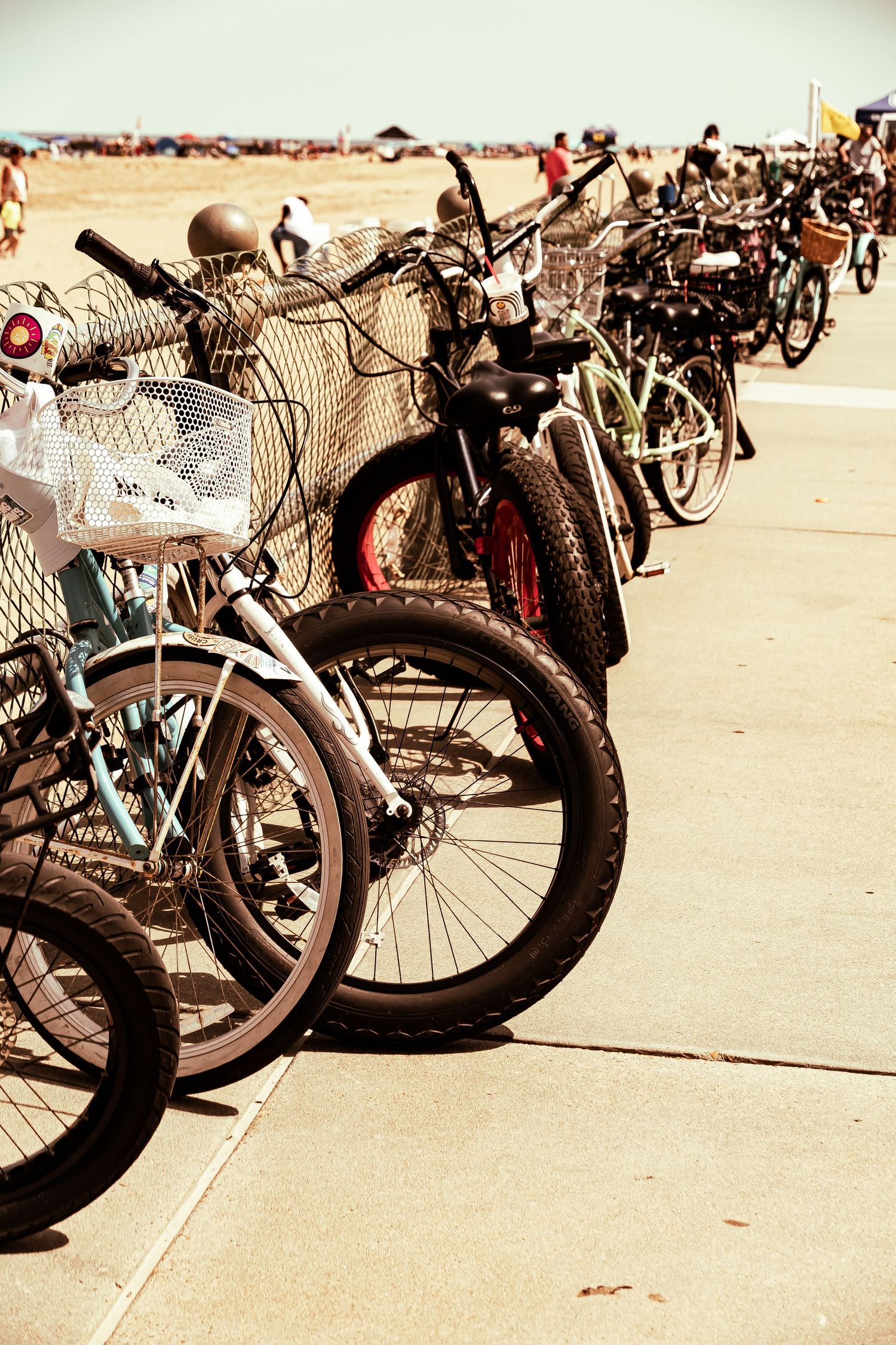 A row of parked bicycles lined up at a bike rack on a sunny concrete surface with vintage style lighting effect.