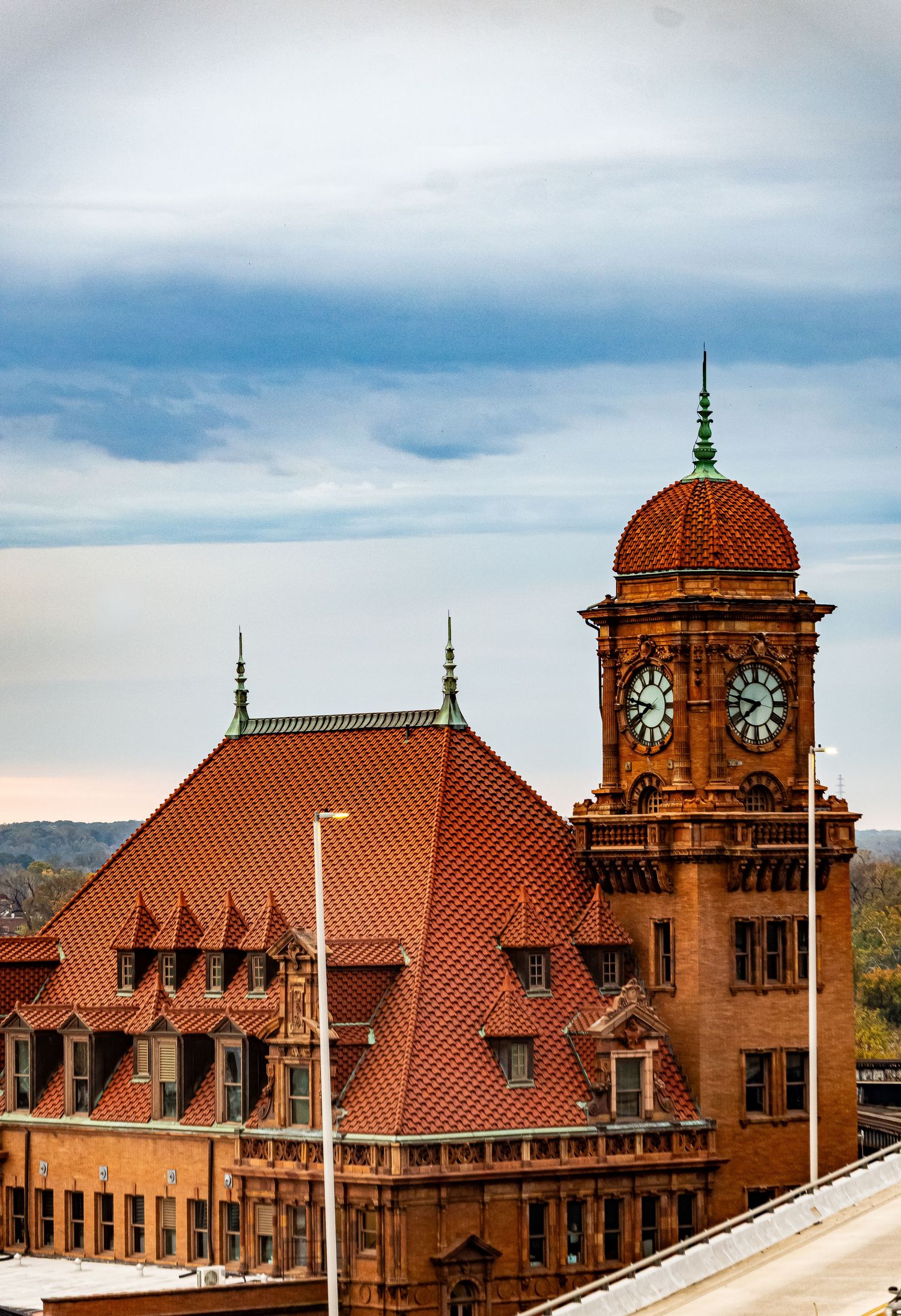 Historic Main Street Station with red terracotta roof and clock tower in Richmond, Virginia against cloudy sky.