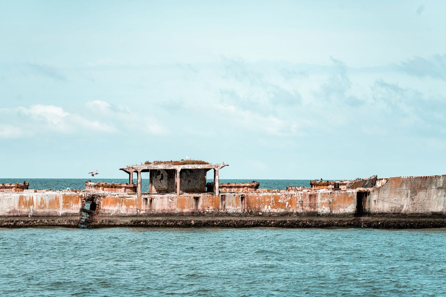 Panoramic view of a historic coastal fort with turquoise waters and blue sky in the background.