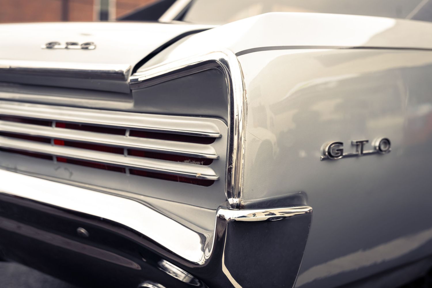 Close-up detail shots of classic car chrome trim and bodywork showing reflective surfaces and elegant design elements.