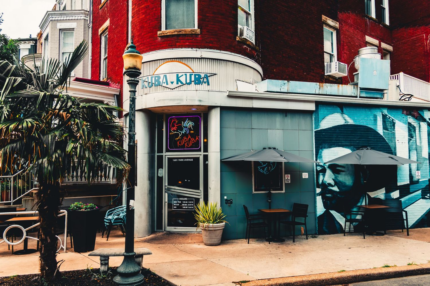 A series of connected storefront photos showing teal and red colored buildings with awnings and palm trees.
