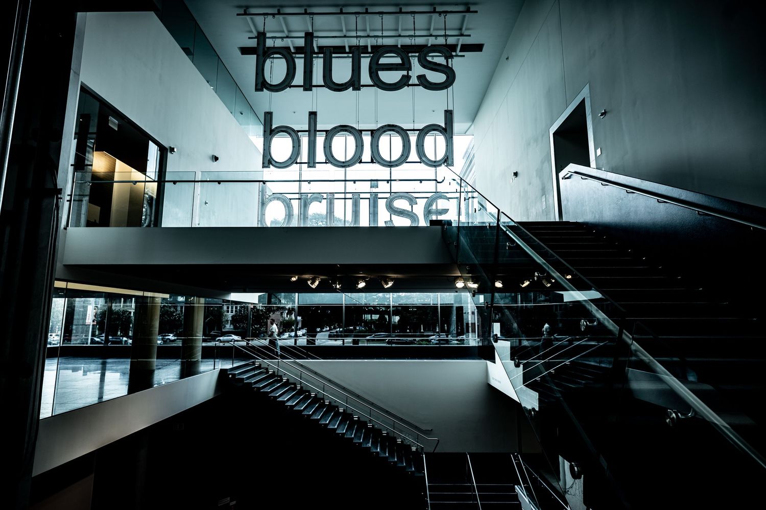 Modern retail store interior with illuminated 'biblos' signage and sleek architectural design in dark lighting.
