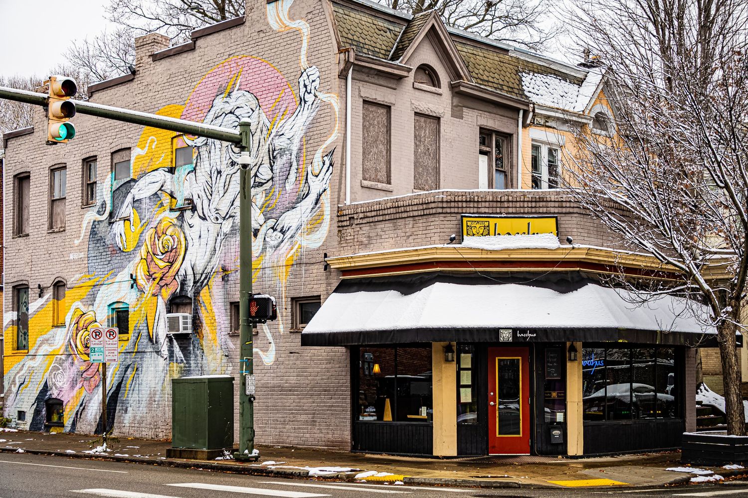 A panoramic view of small town storefronts and businesses along a snowy winter street.