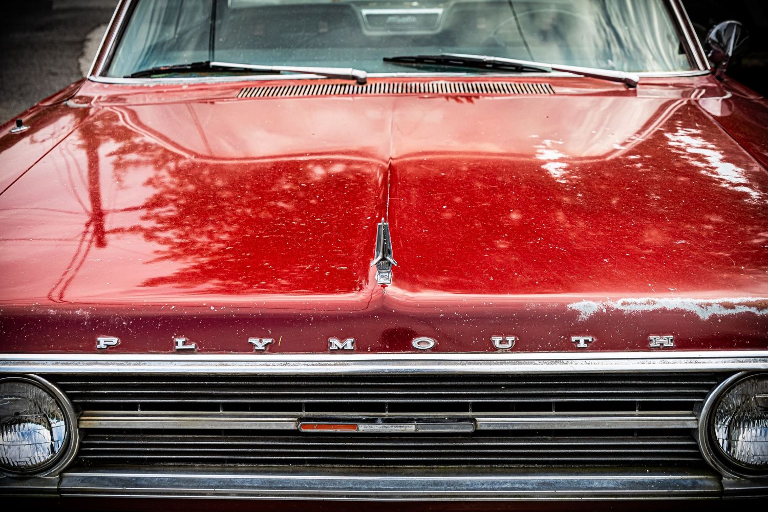 A collection of vintage red car details showing chrome trim, windshields, and bodywork in a horizontal photo series.