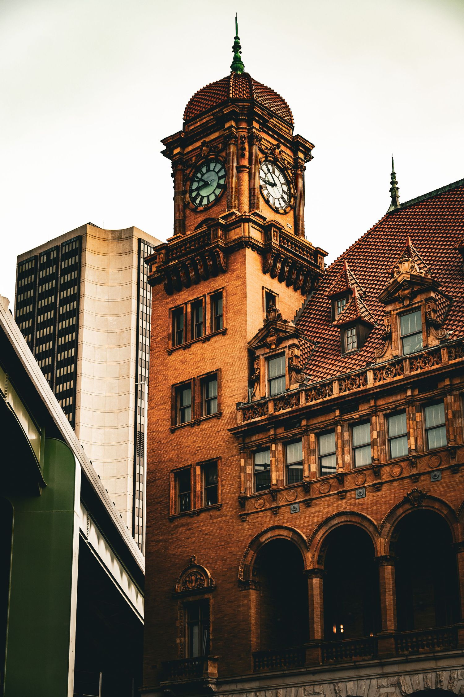Historic red brick train station building with ornate Victorian architecture and clock tower in warm evening light.