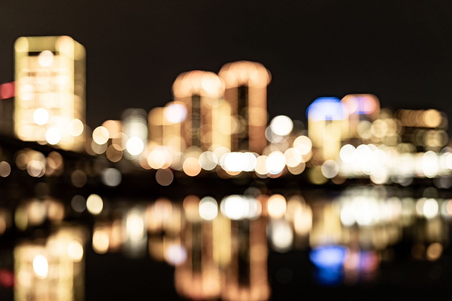 Blurred city lights create a dreamy bokeh effect against a dark nighttime background.