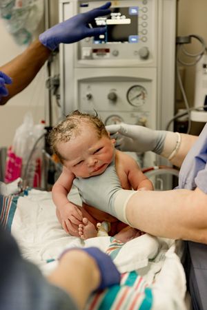 Baby being weighed during birth photography session with Tiffany Bergamino Photography