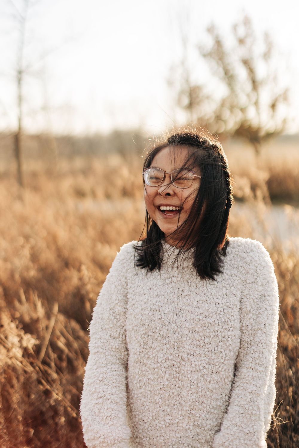Joyful outdoor portrait in a natural autumn setting with golden light.