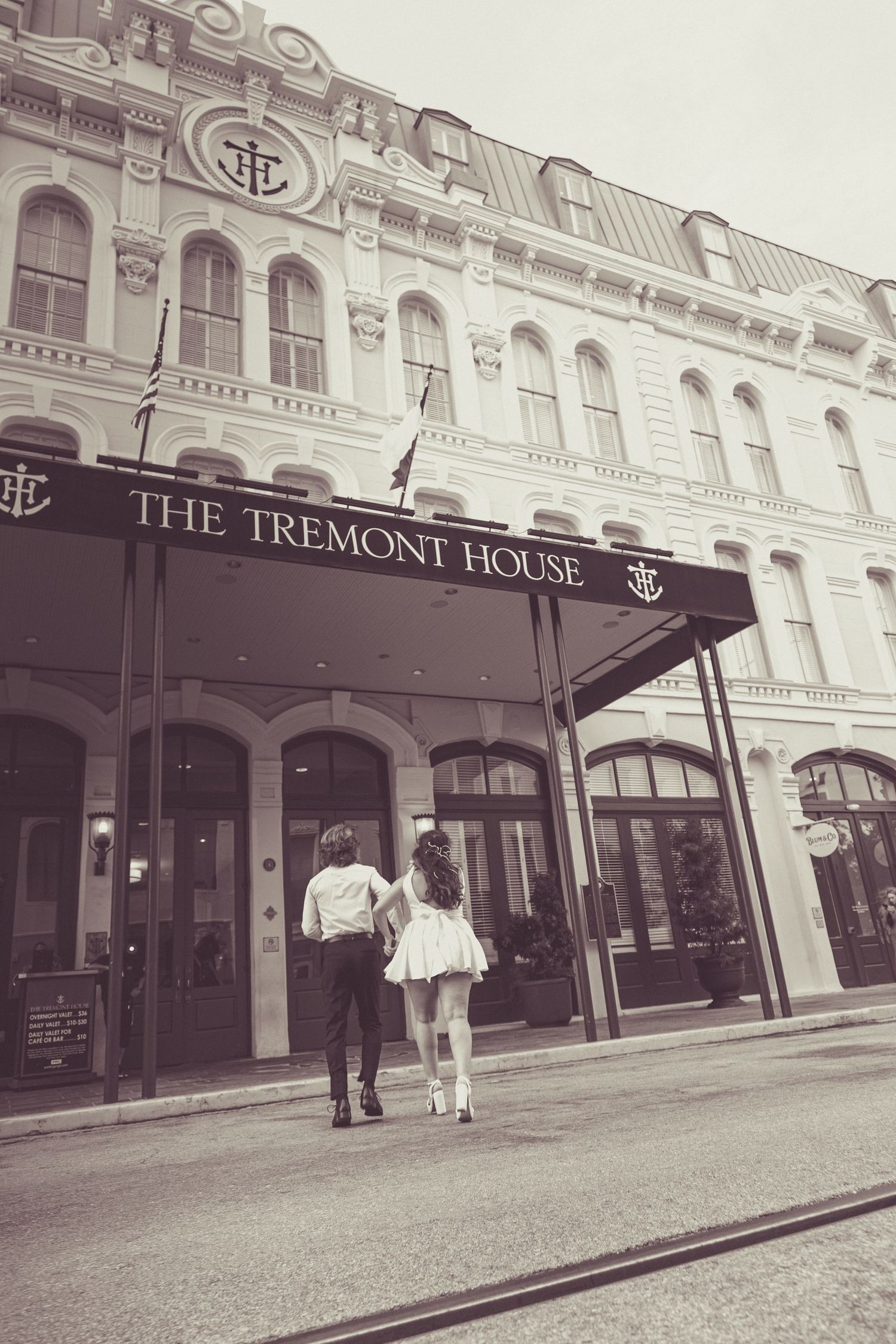 A vintage-style photo of a couple walking towards The Tremont House entrance.
