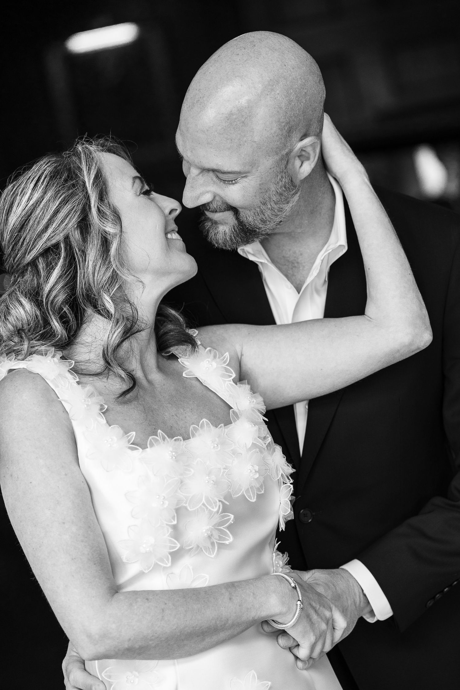 A romantic black and white photo series of a bride and groom sharing intimate dance floor moments at their wedding reception.