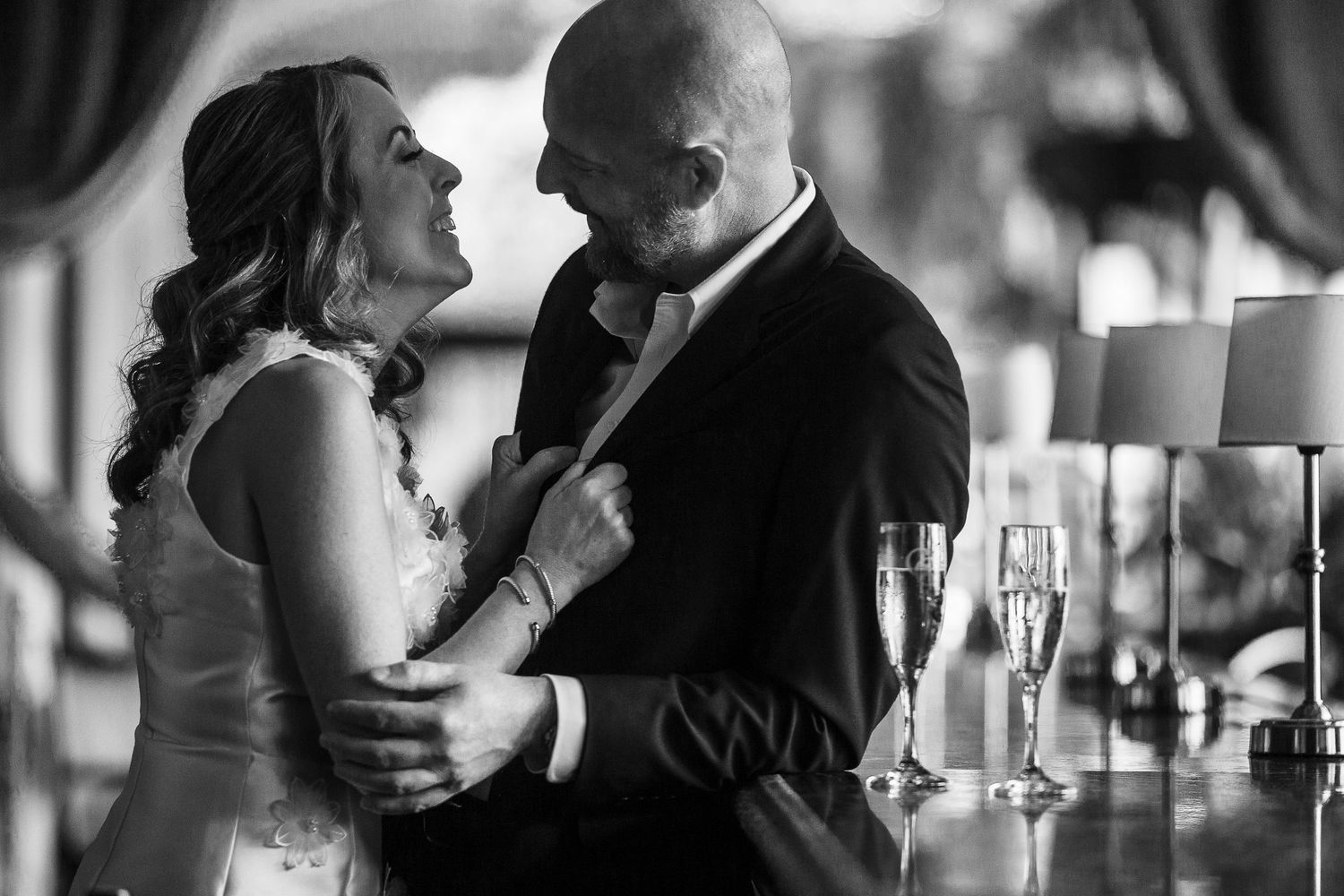 A romantic black and white collage of couples sharing intimate moments with champagne glasses and candlelight.