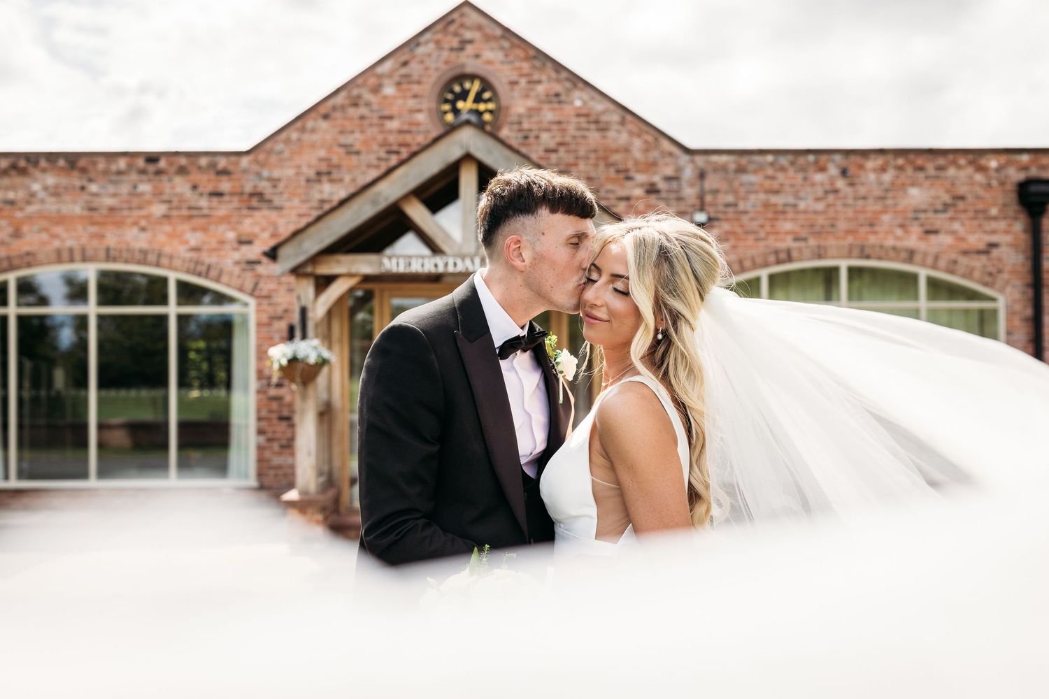 Merrydale manor wedding. Groom kisses bride.
