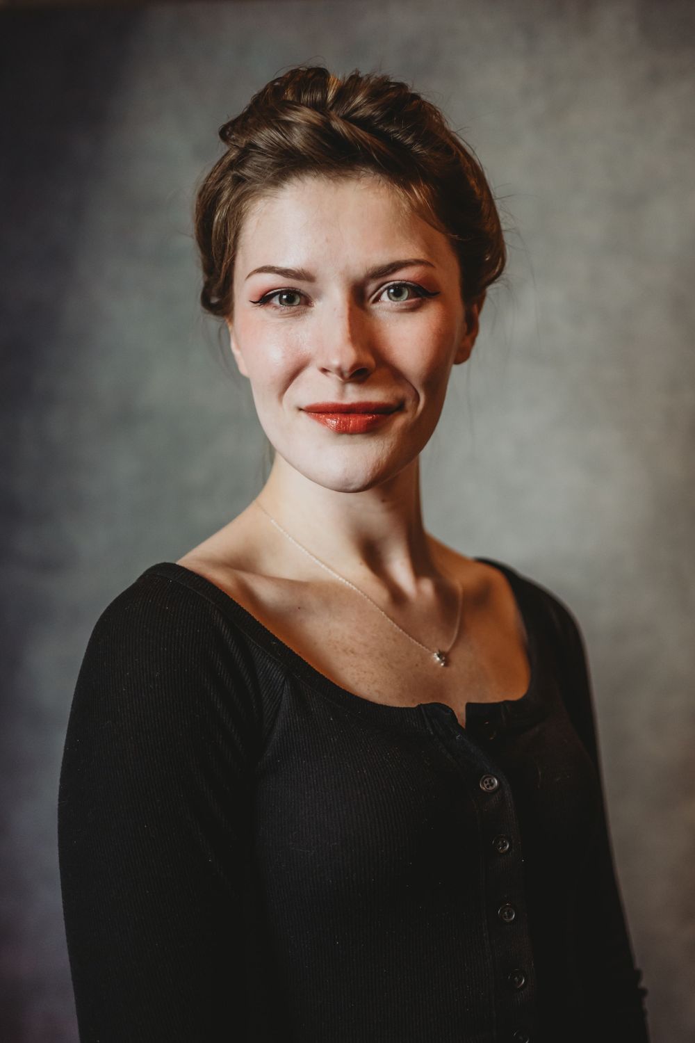Portrait series showing expressive faces in black clothing against textured gray background.