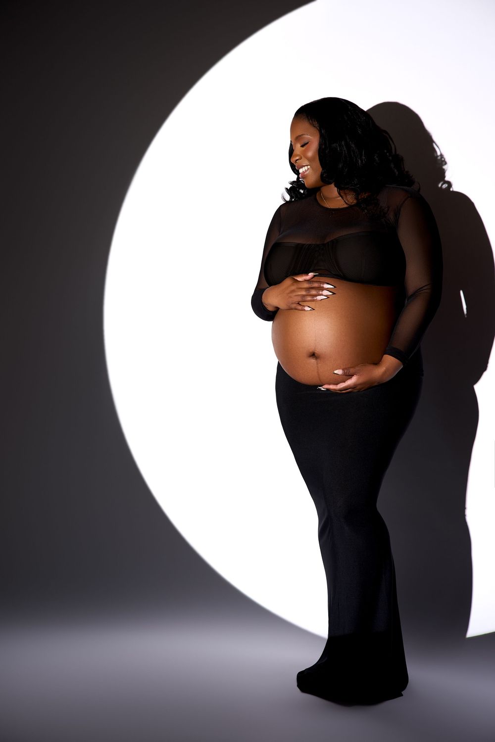 A series of artistic maternity photos showing a silhouetted figure in black against a white backdrop.