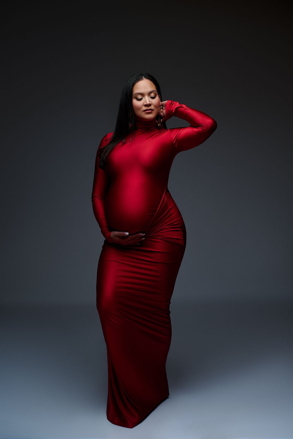 A series of artistic maternity photos showing a woman in a flowing red dress posing gracefully against a dark backdrop. gricels photography