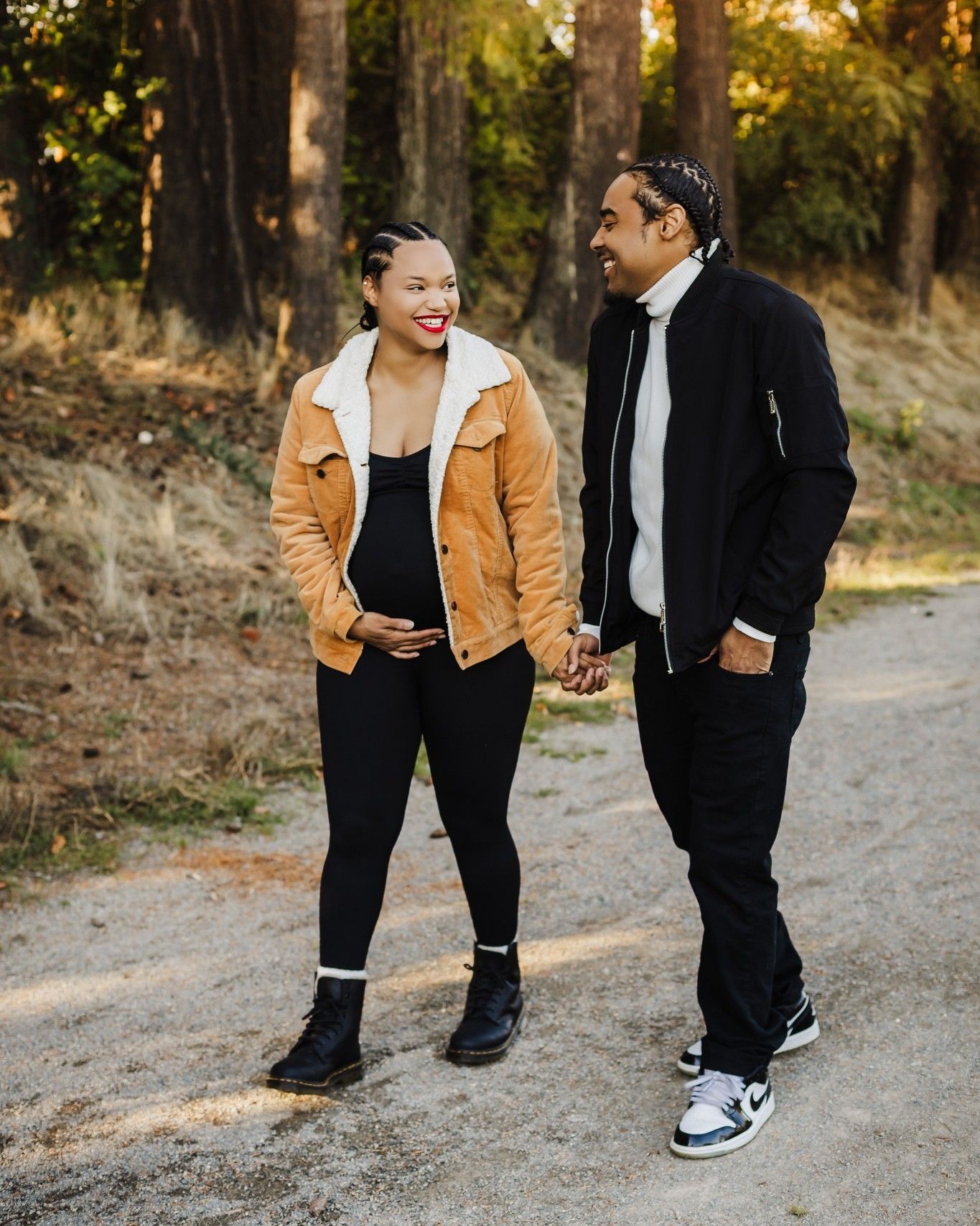 A couple in matching winter jackets walking together on an autumn path.