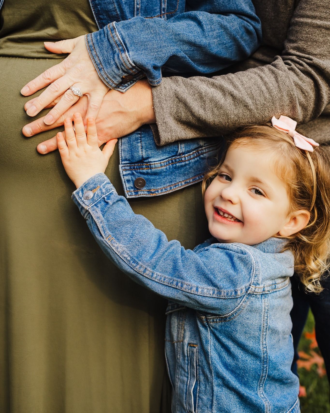 A joyful moment of hands stacked together wearing denim.