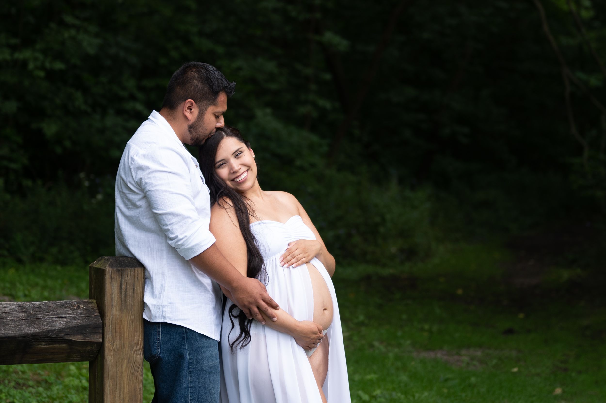 A maternity photoshoot in a peaceful woodland setting.