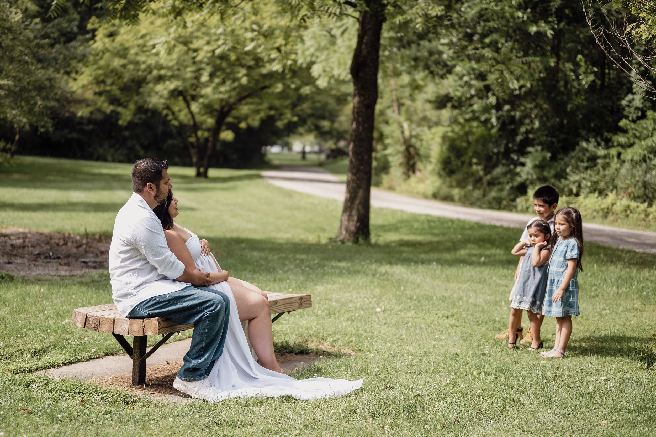 A peaceful outdoor maternity photo session in a park setting.