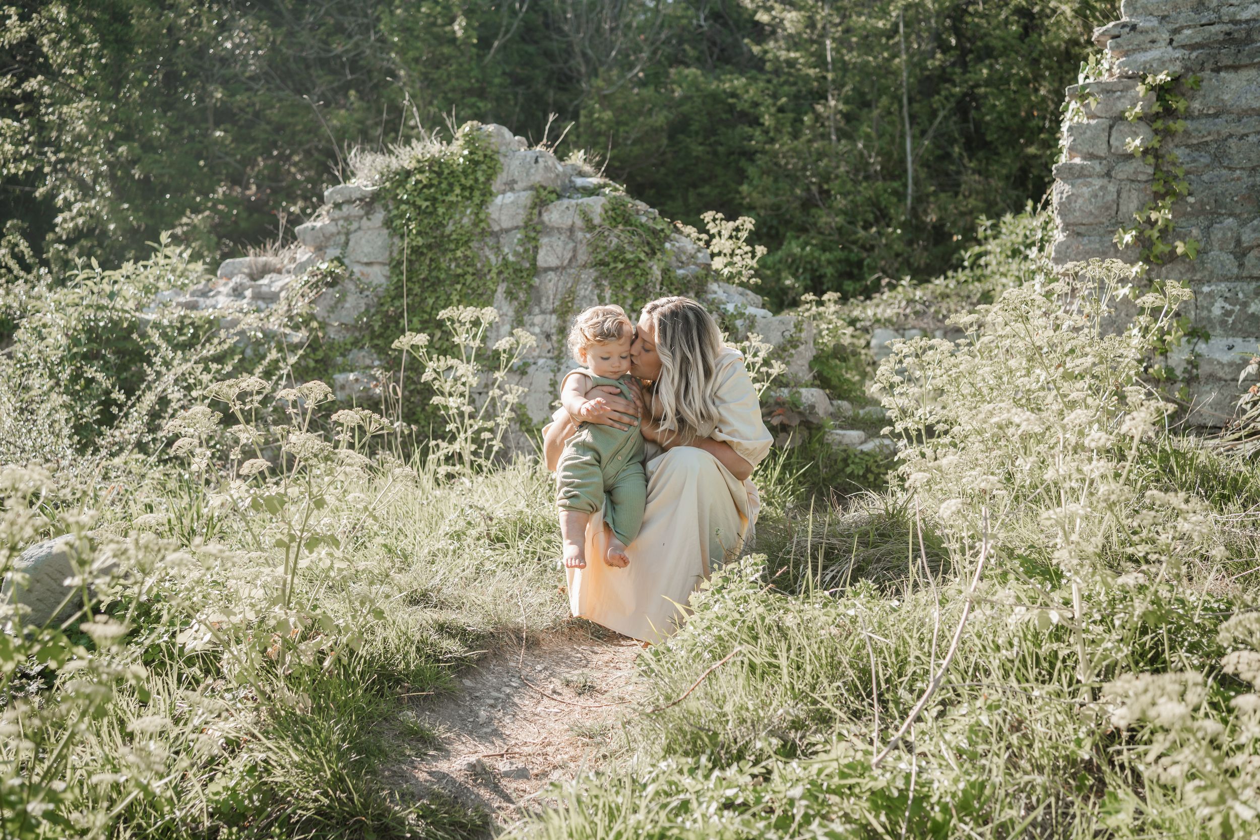 Mum kissing toddler in wildflowers during a photoshoot on the Isle of  Portland, Dorset - captured by a local in-home newborn photographer