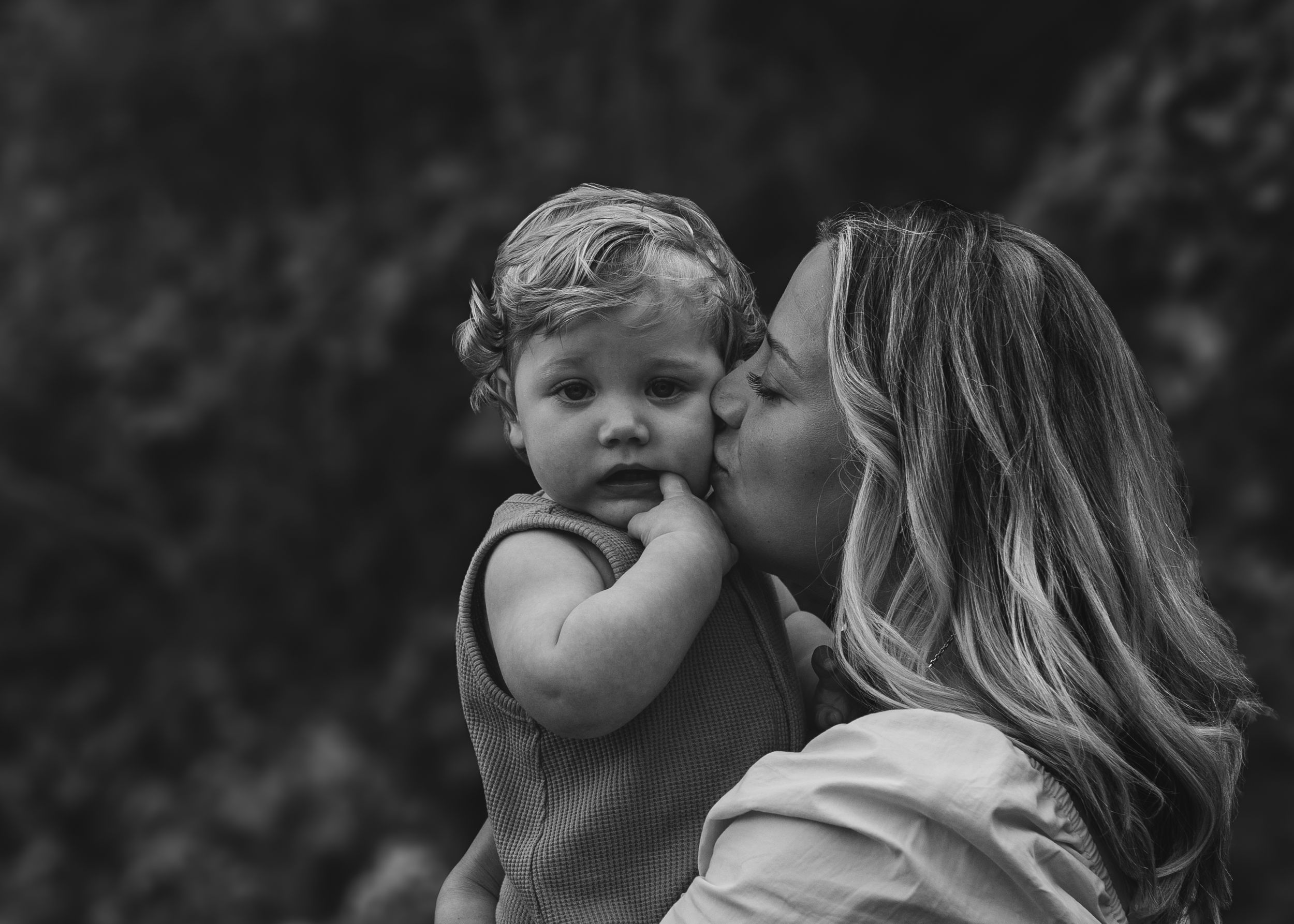 A mum kissing her toddler during an in-home + outdoor photoshoot taken on the Isle of Portland, Dorset by newborn photographer Emma Tennant