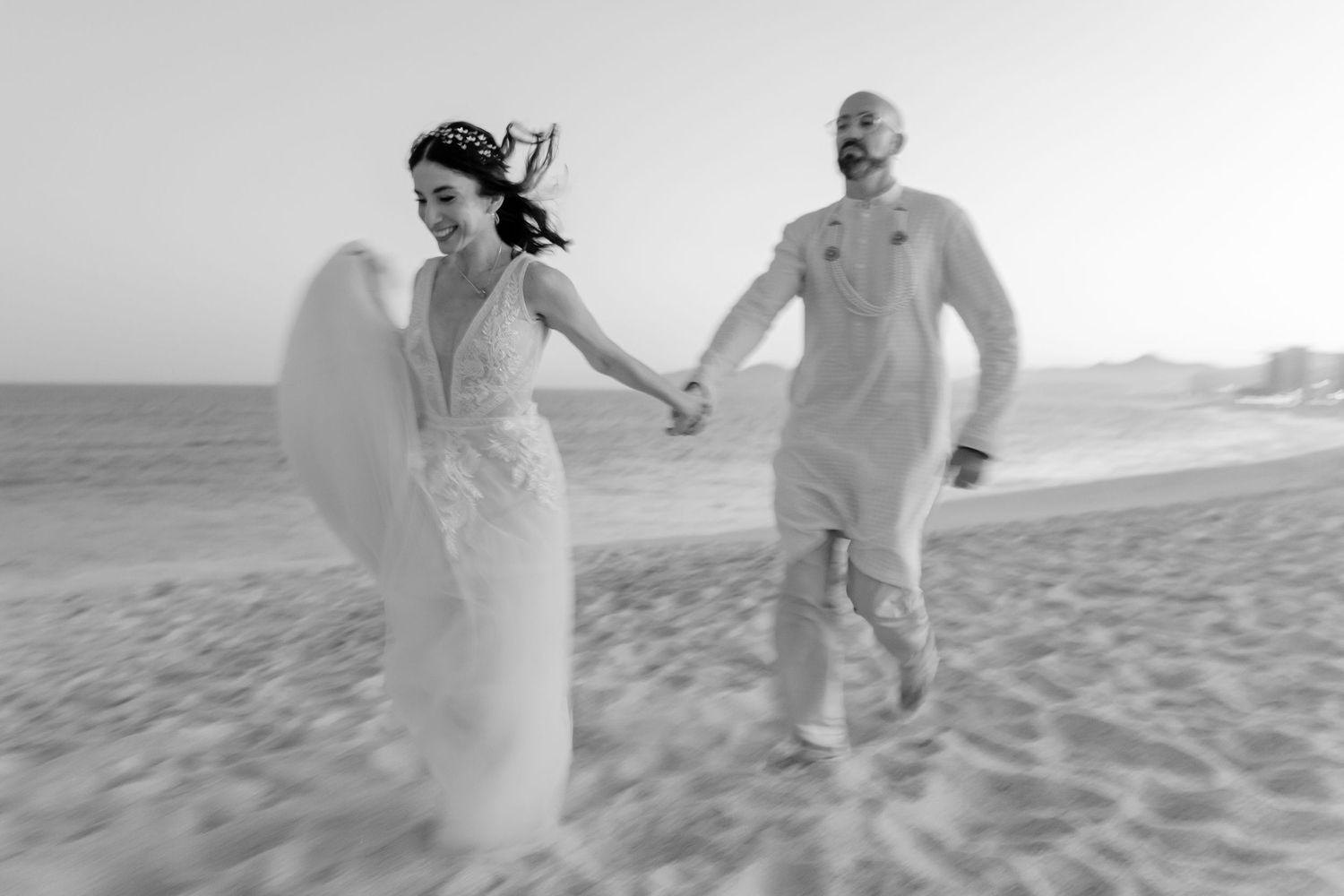 Couple holding hands during sunset session in Cabo