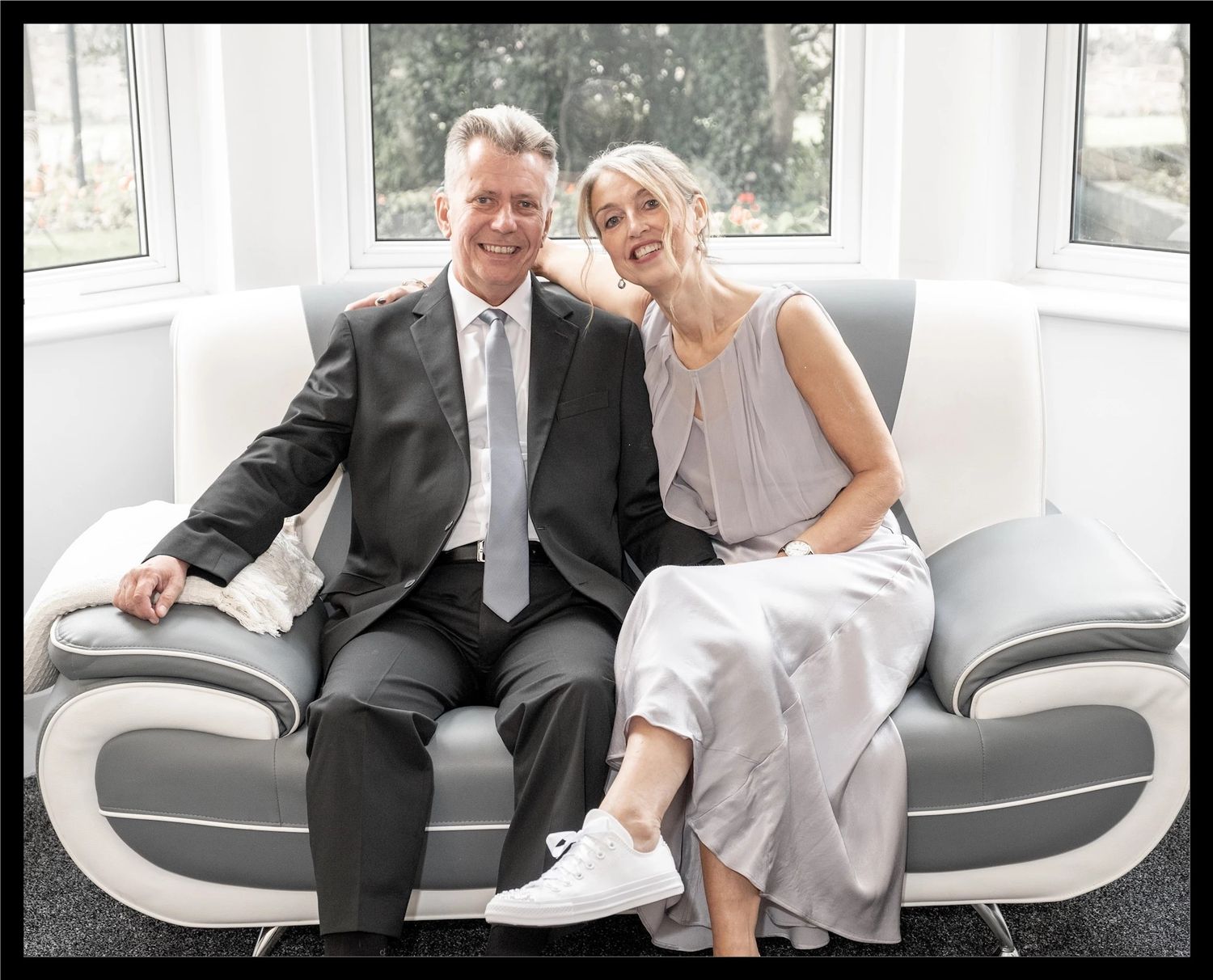 Bride and Groom sitting on a sofa.
