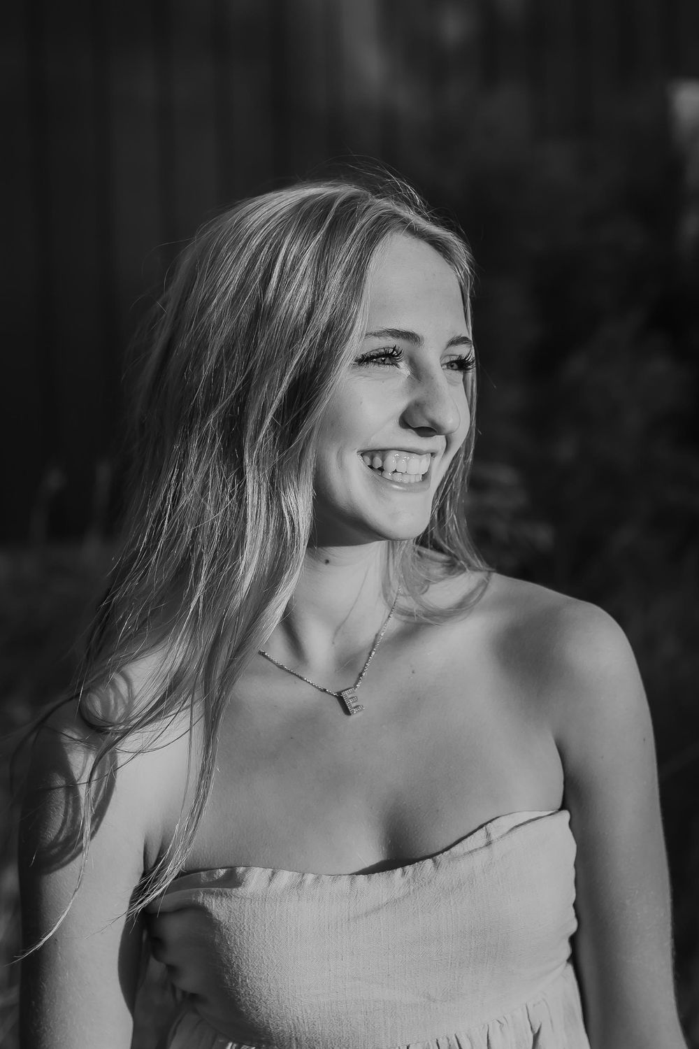 A black and white photography of a high school senior smiling confidently in natural light in Denver