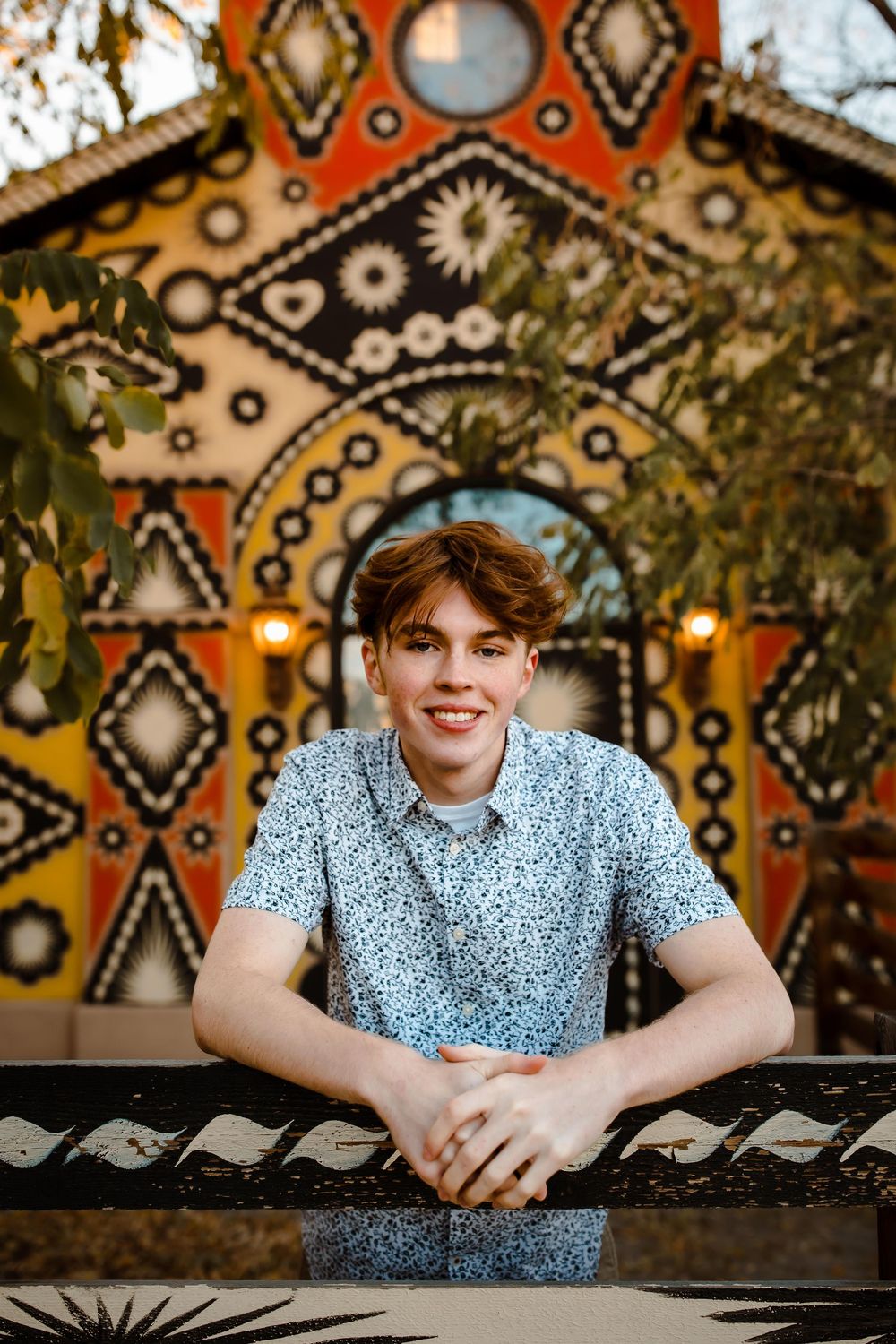 High school senior posing confidently in downtown Denver with colorful mural background