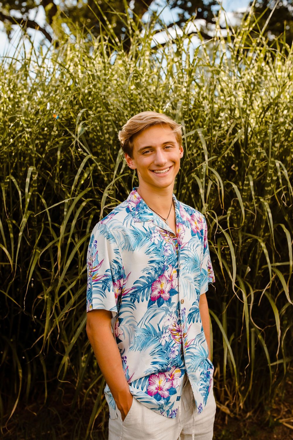 A high school senior smiles confidently at Wash Park in Denver