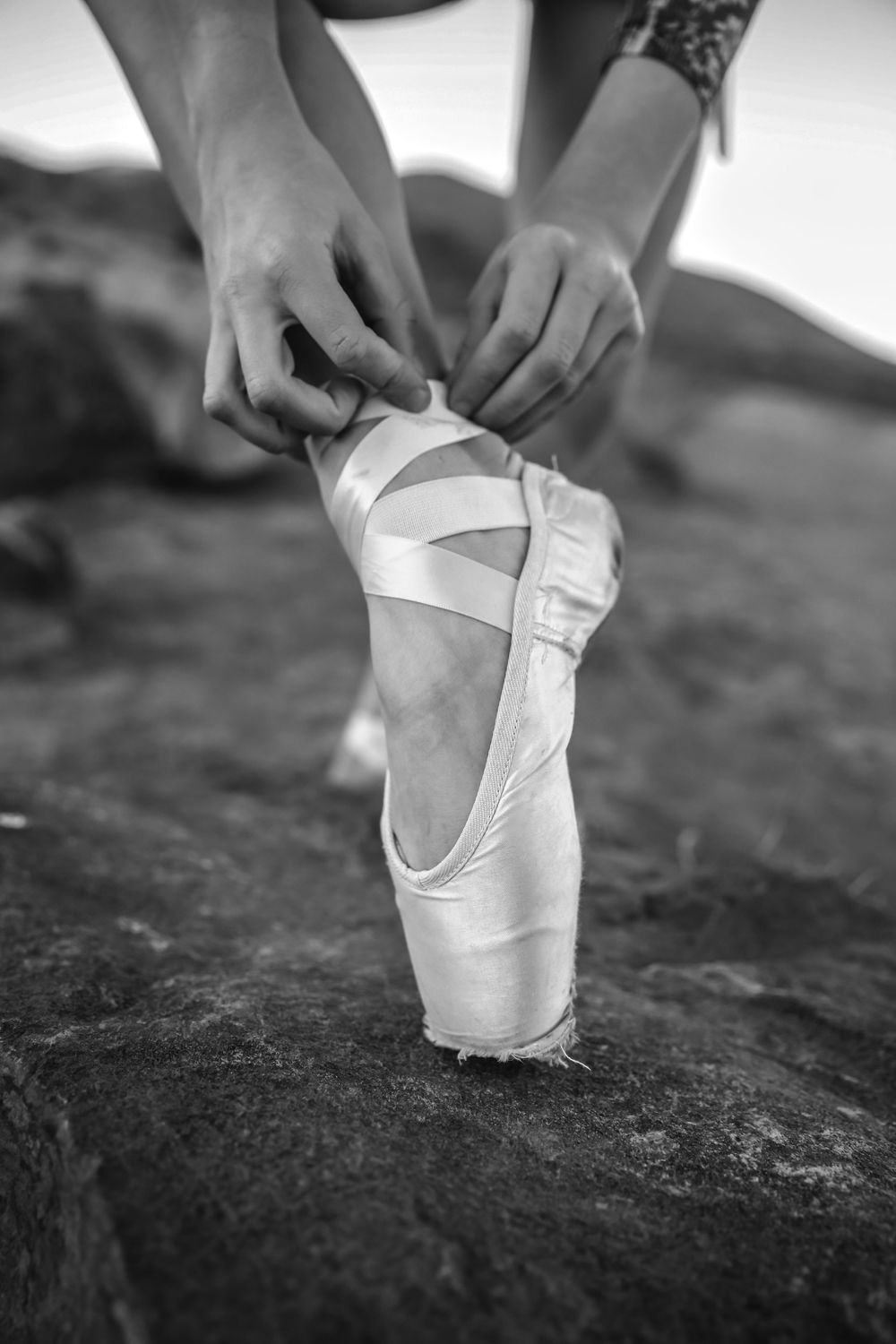A ballerina laces her pointe shoes