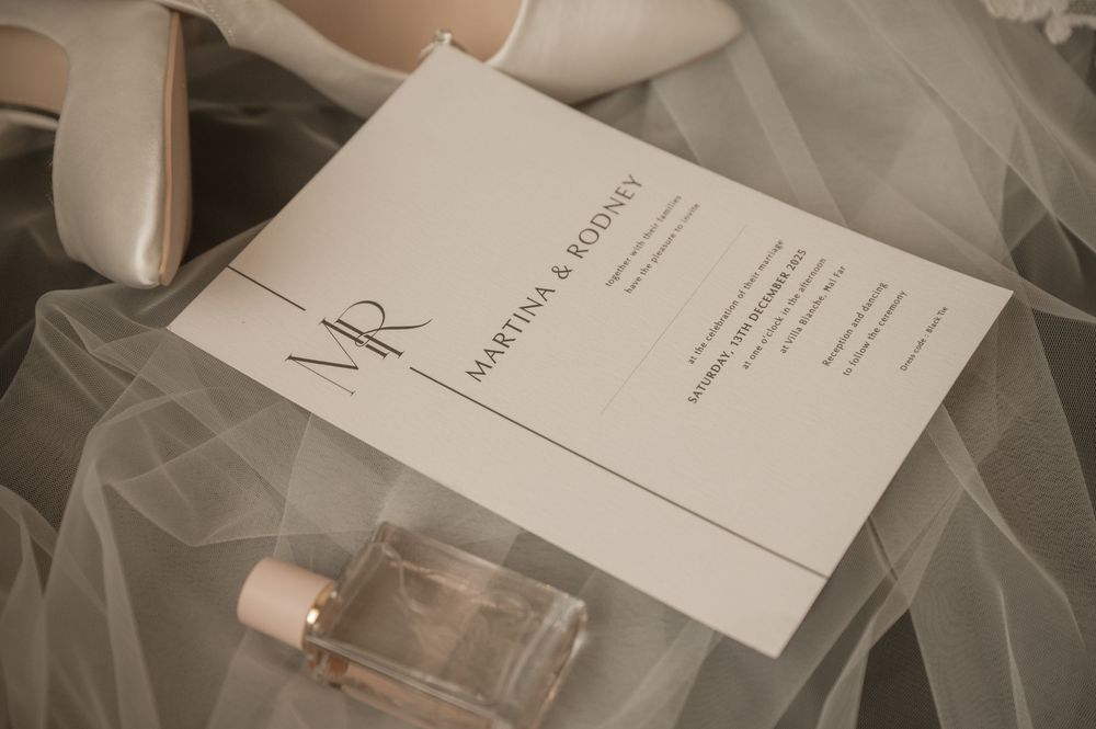 Elegant wedding stationery and invitation cards arranged with delicate veil fabric.