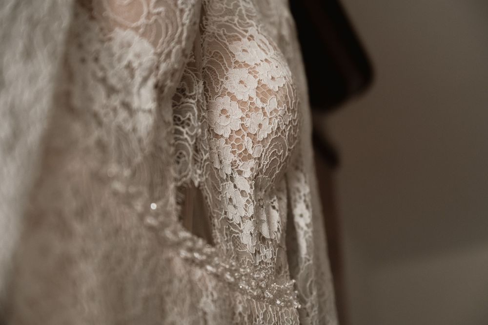 Detailed macro shot of wedding dress lace pattern and beading.