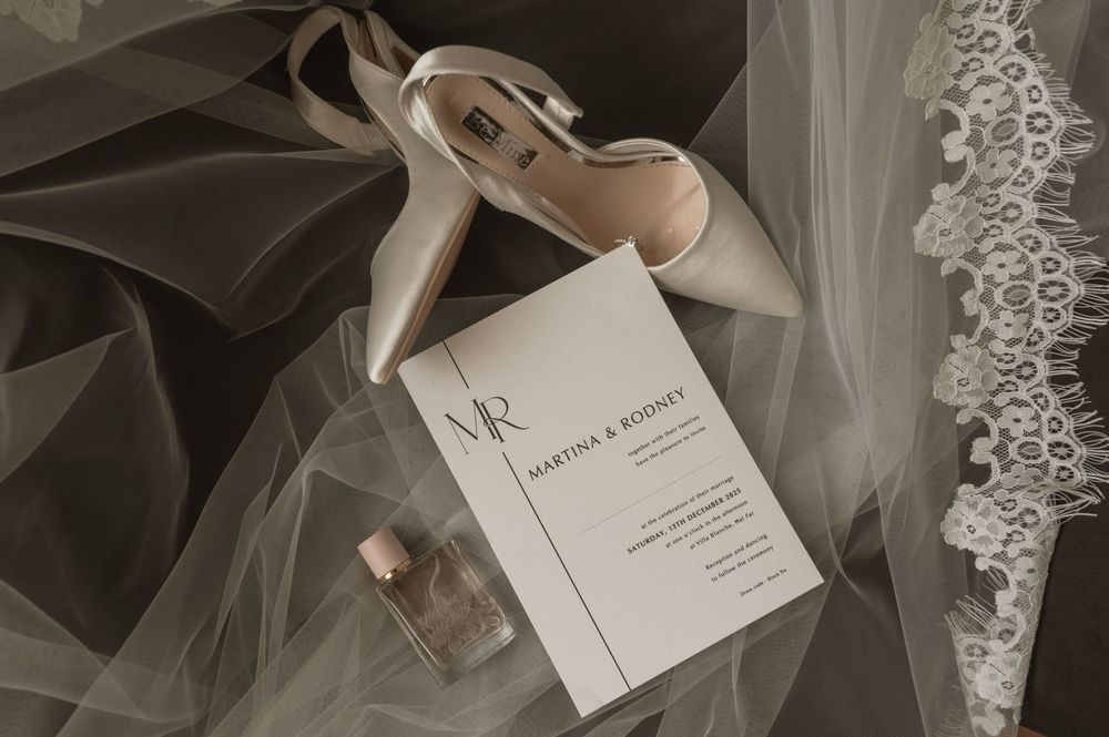 Wedding accessories and stationery artistically arranged with tulle fabric.