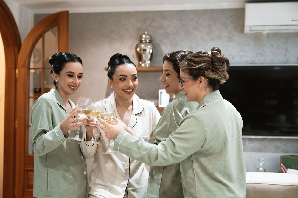 Wedding preparation scene with matching robes and celebratory champagne toast.