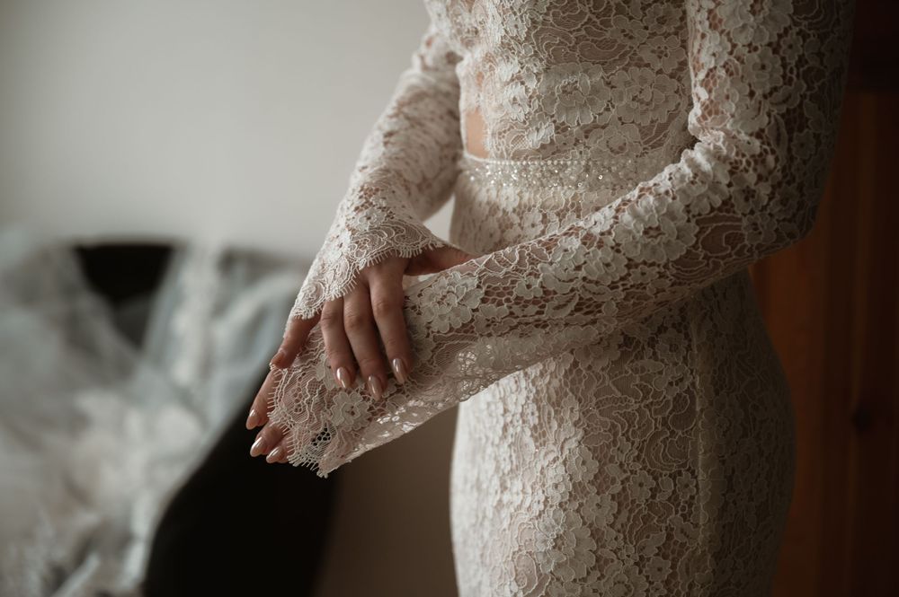 Artistic shots of bride's lace wedding gown details in natural window light.