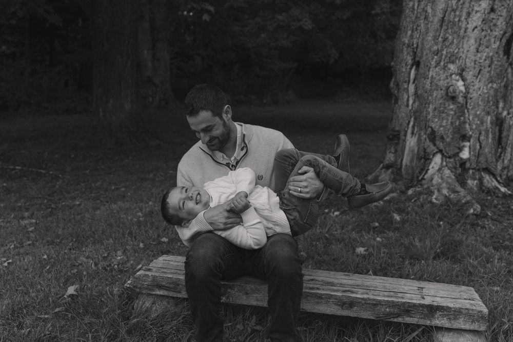 A black and white photo showing tender family moments outdoors.