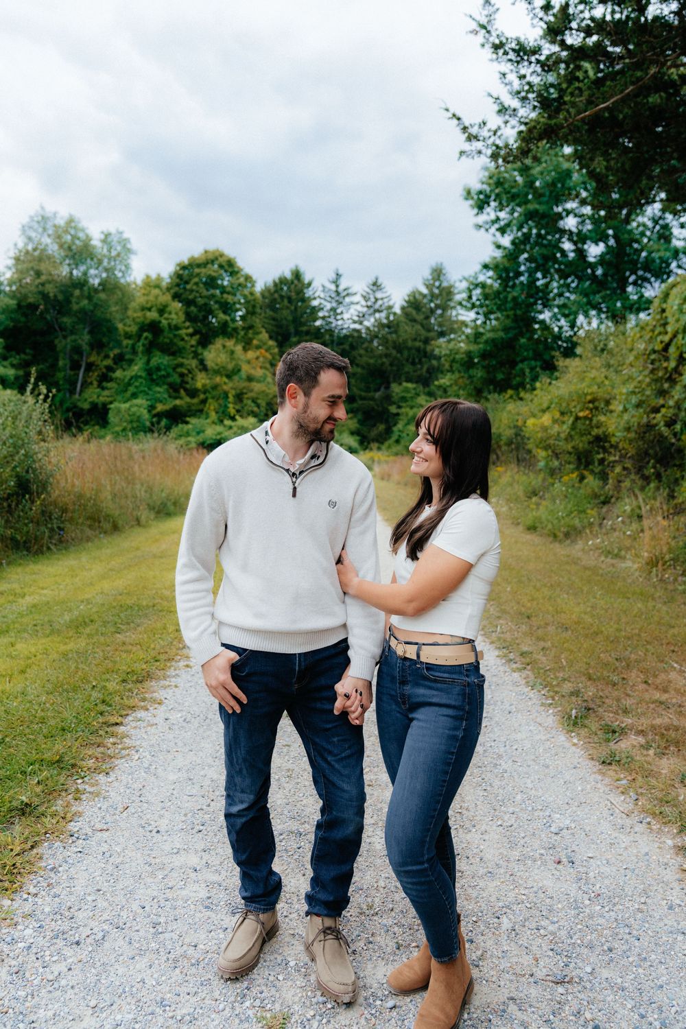 Sweet candid interactions between a couple on a sunny autumn path.