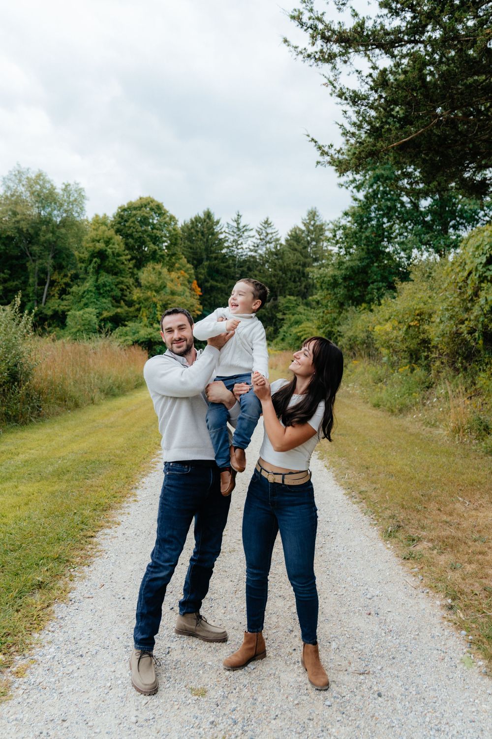 Playful couple sharing laughs and embraces on a gravel trail.