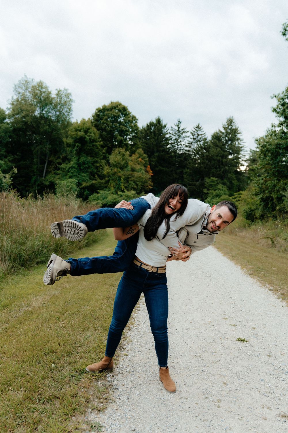 Playful sequence of someone balancing on one leg while walking along a gravel path outdoors.