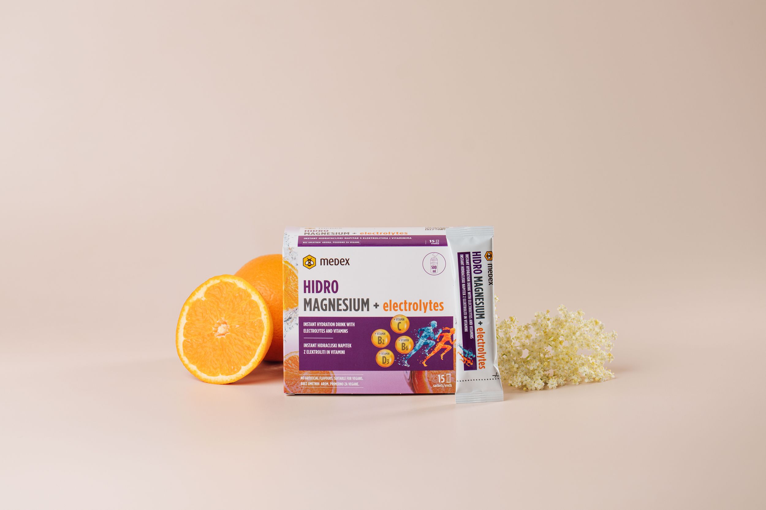 Skincare products displayed with orange slices and floral elements on beige background.
