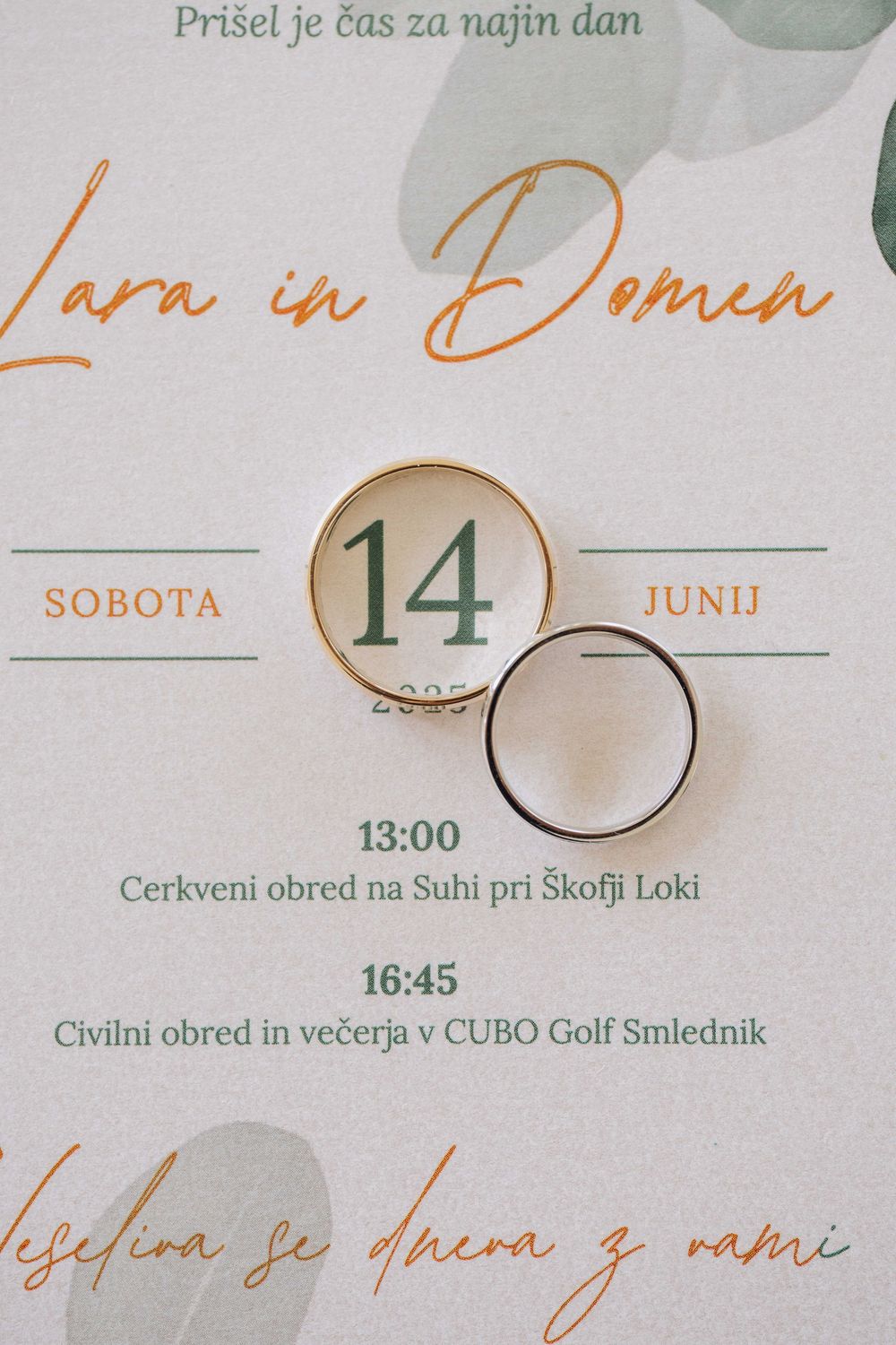Wedding invitation details showing date June 14th with elegant gold text and wedding rings.