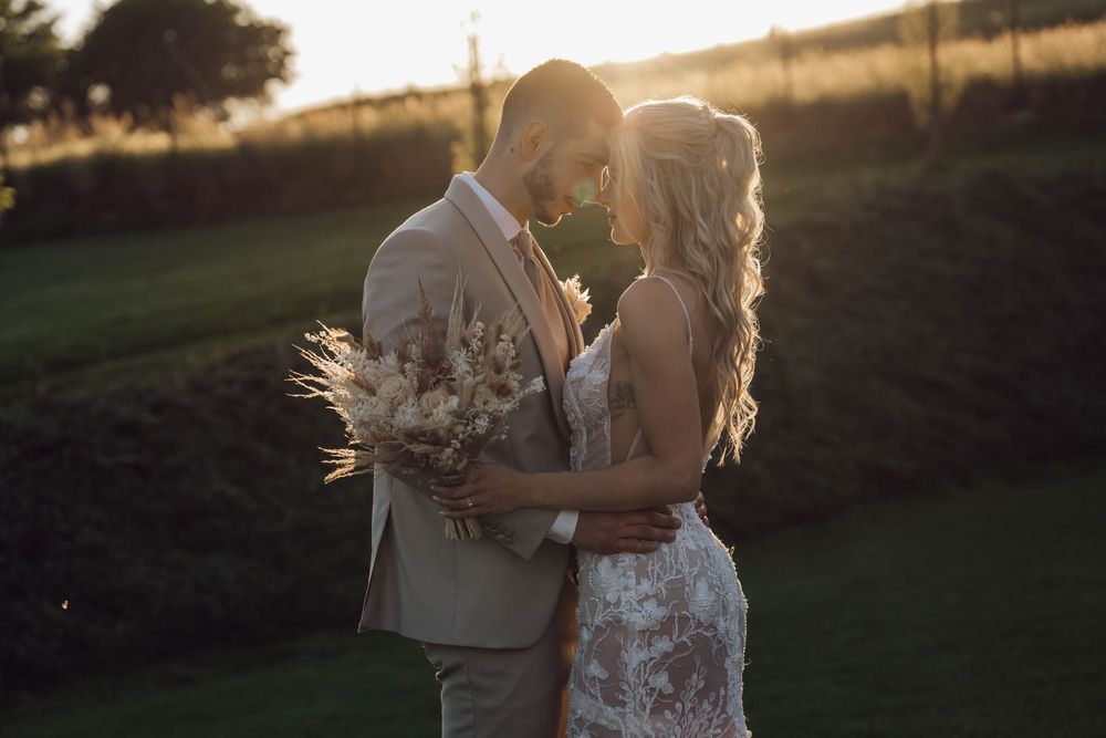 Romantic golden hour wedding photography in a natural outdoor setting.