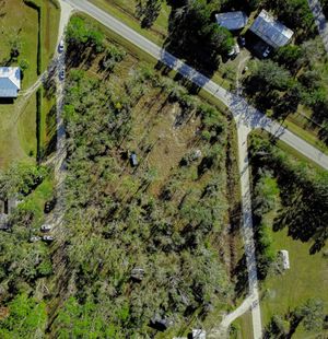 Aerial view of country roads winding through green rural landscape with scattered houses and tree coverage.